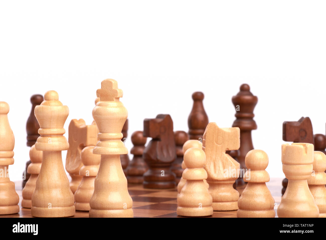 Jouer un jeu d'échecs ou d'une bataille. Pièces en bois blanc et noir sur le conseil et la planification d'une stratégie de l'équipe commune - Isolé sur fond blanc. Banque D'Images