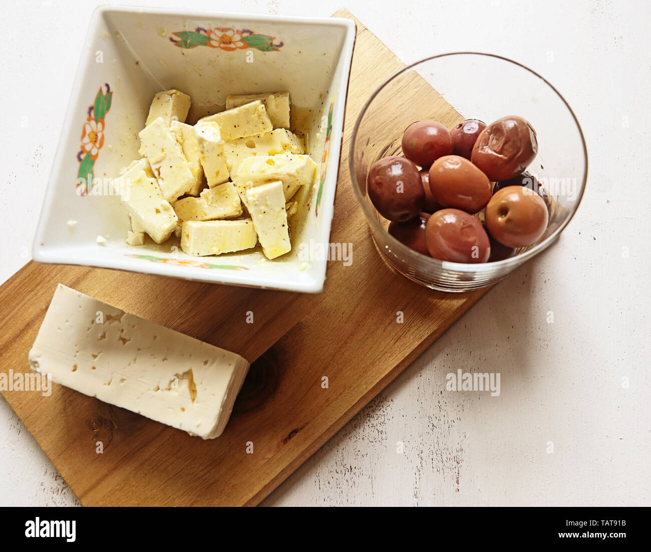 Le fromage Feta habillé avec le poivre et l'huile d'olive et olives noires grecques Banque D'Images