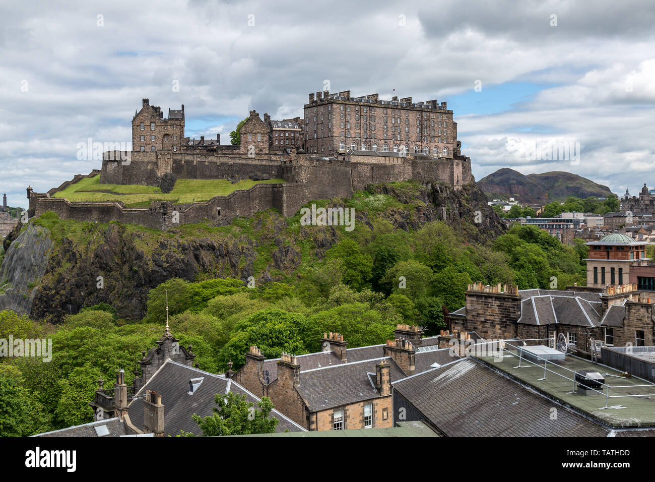 La recherche à travers des toits vers le château d'Édimbourg en Écosse.avec l'ancien fort de la colline Arthur's Seat en arrière-plan. Banque D'Images
