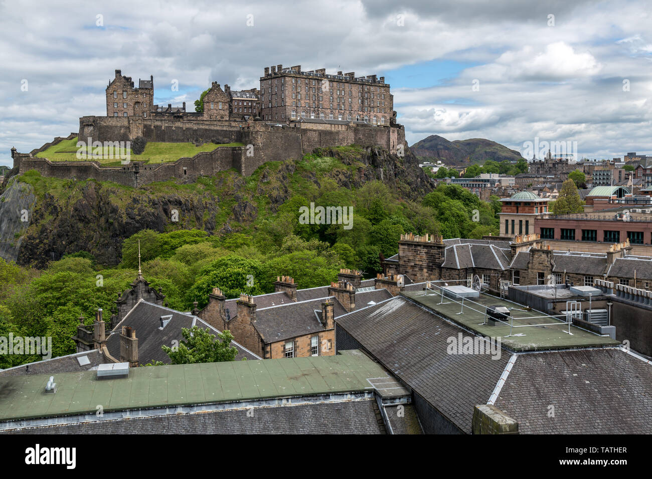 La recherche à travers des toits vers le château d'Édimbourg en Écosse.avec l'ancien fort de la colline Arthur's Seat en arrière-plan. Banque D'Images
