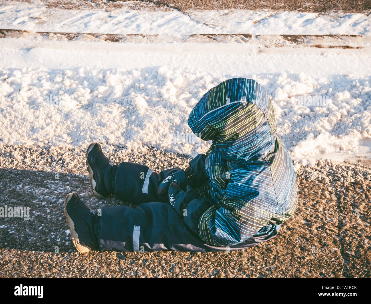 Peu bouleversé baby boy sitting sur route asphaltée. Pour l'humeur, mauvaise conduite, d'obéissance, emper concept de colère. L'espace de copie pour le texte. Banque D'Images