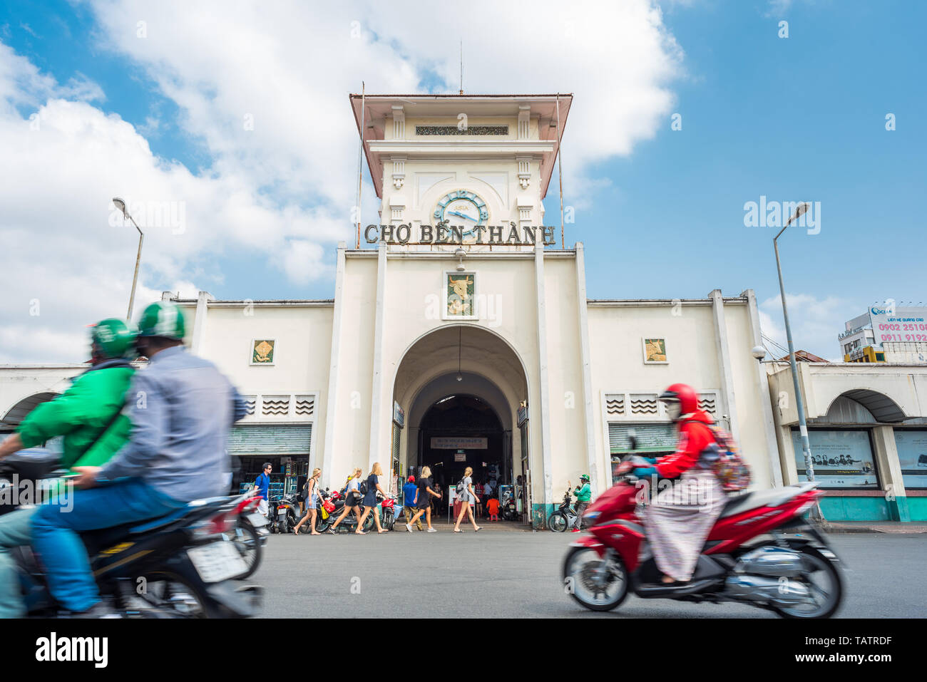 Ho Chi Minh Ville, Vietnam - 8 Avril 2019 : la façade de marché de Ben Thanh avec un groupe de filles blondes et la circulation de plus en plus floue dans motion. Banque D'Images
