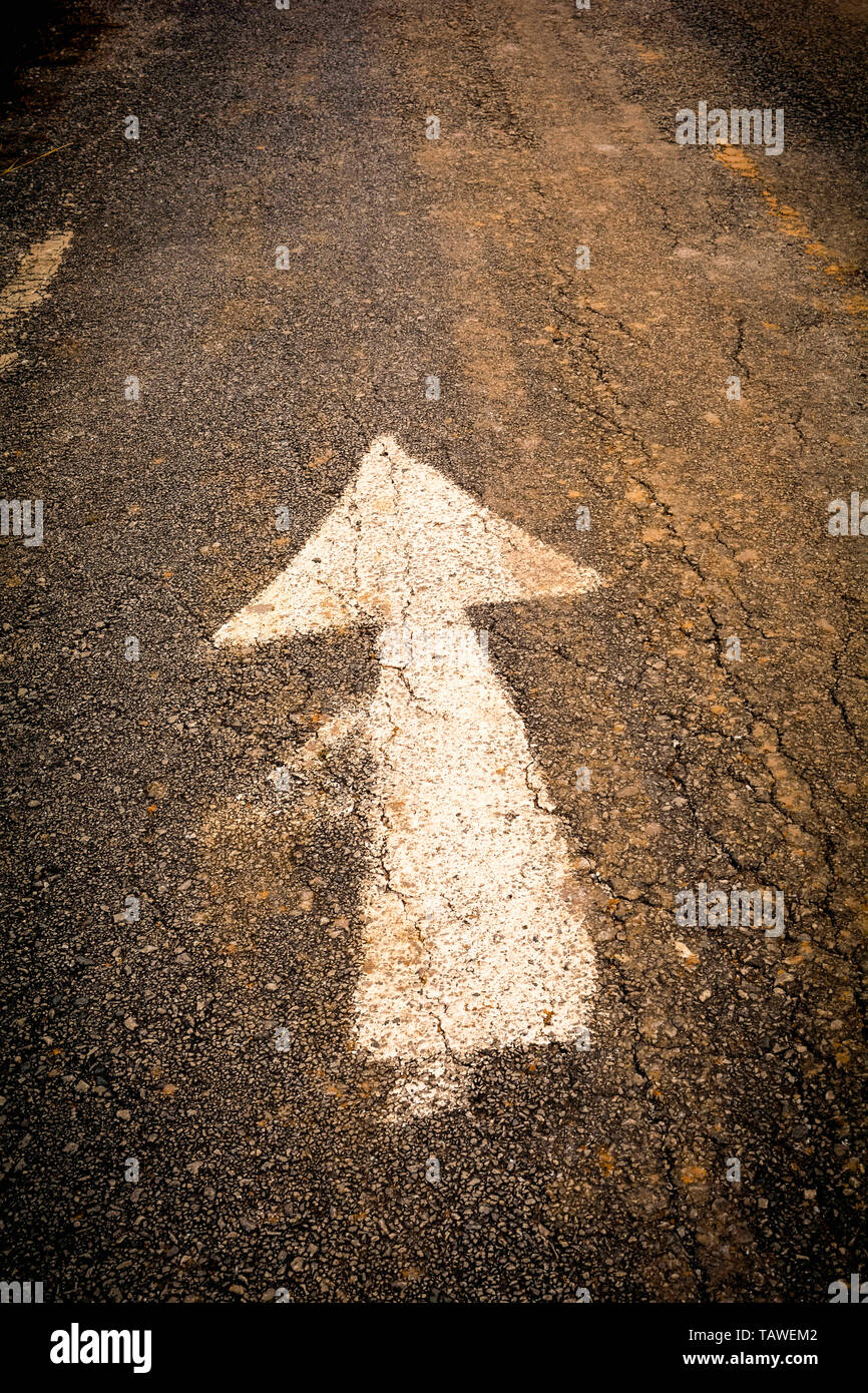 Flèche blanche sur l'avant de la route sur de vieux panneaux route asphaltée texture background Banque D'Images