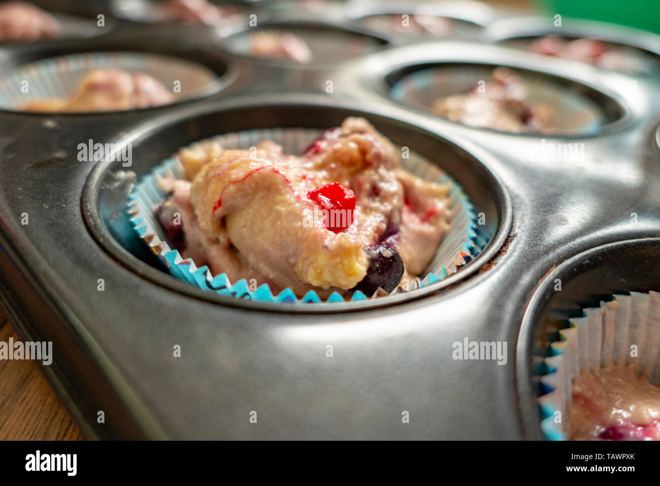 Pâte crue avec des fruits pour de délicieux muffins à la tin Banque D'Images