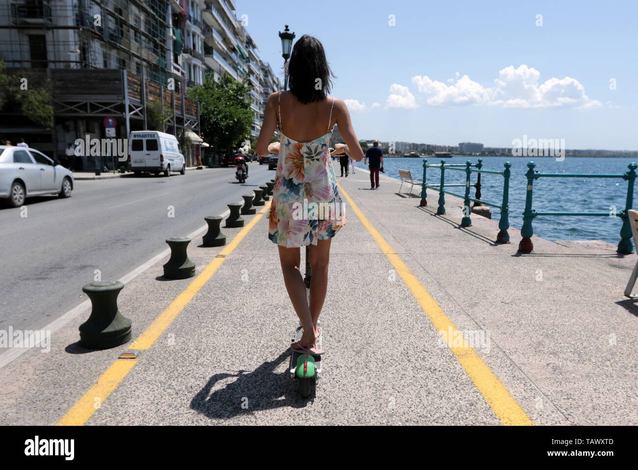Femme sur un vert électrique scooter sur un cycle way promenade à Thessalonique, en Grèce. Banque D'Images