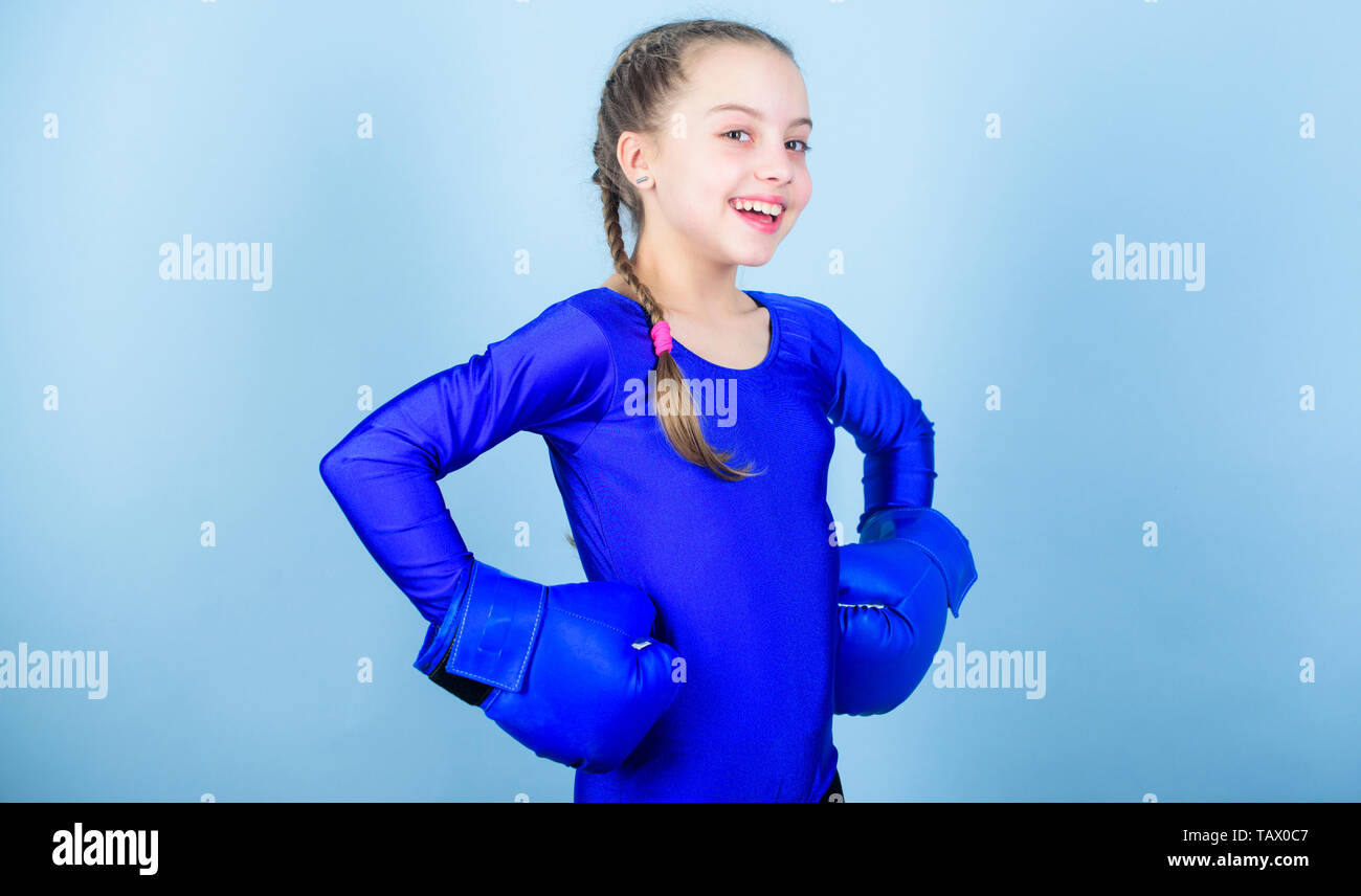 Heureux l'enfant sportsman dans des gants de boxe. Séance d'entraînement de petite fille boxer perforatrice knock-out. L'activité de la petite enfance. Fitness diet. énergie santé. Le succès de la mode sportswear Sport.. Se détendre après la formation. Banque D'Images