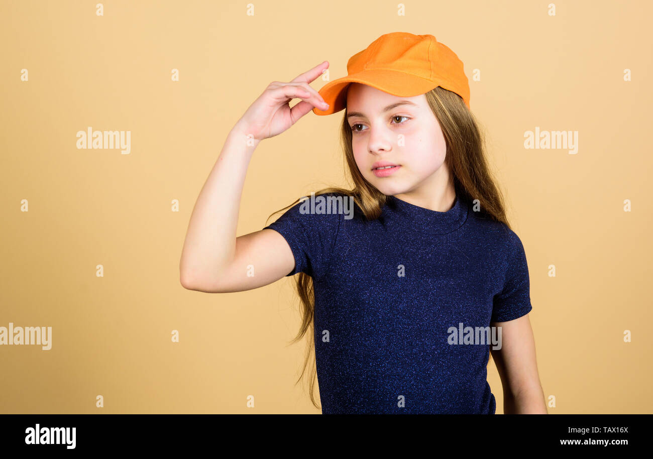 Cute Girl porter à votre enfant une casquette ou chapeau snapback fond  beige. Little girl wearing baseball cap lumineux. La mode moderne. Chapeau  ou casquette. Accessoire élégant. Kids Fashion. Un sentiment de
