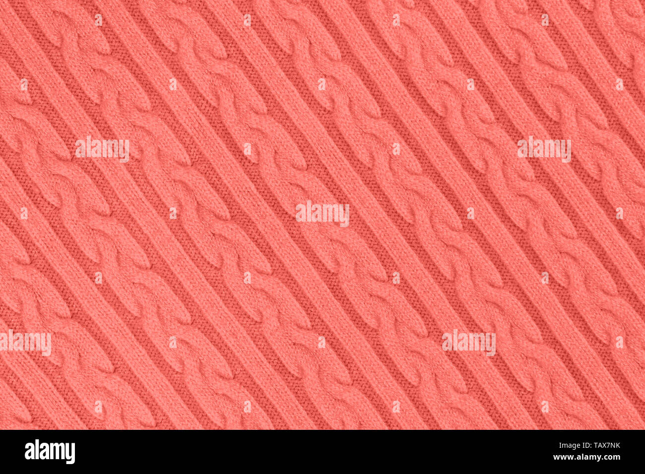 De couleur corail très tendance Tissu Tricot Texture avec des Tresses et de rayures. Tricot Machine répéter la texture de chandail. En arrière-plan. La diagonale Banque D'Images