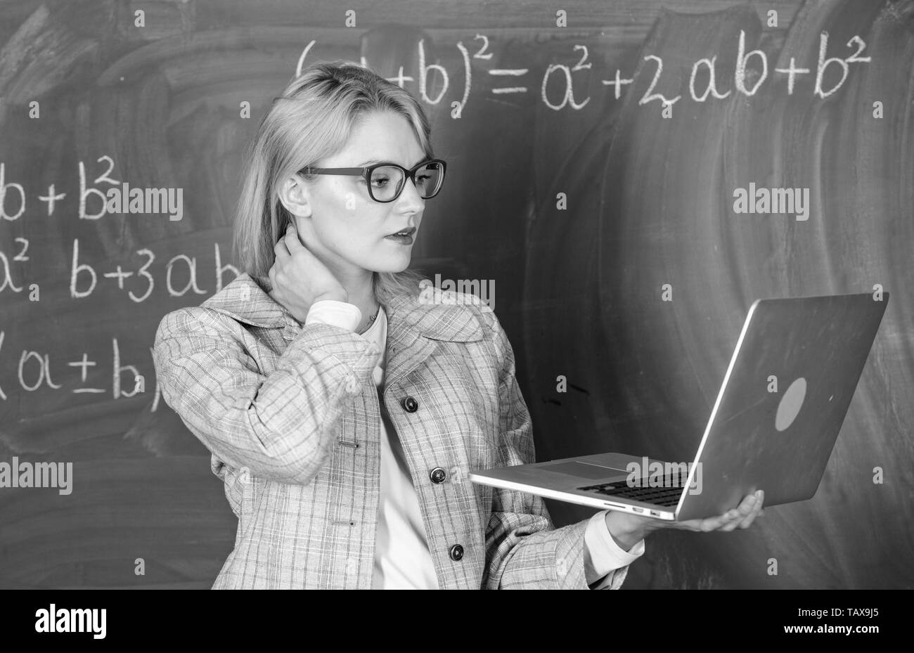 L'innovation de l'école. Concept de formation à distance. L'enseignant détient dame portent des lunettes pour ordinateur portable Internet surf. Femme blonde enseignant avec ordinateur portable moderne tableau internet surf arrière-plan. Banque D'Images