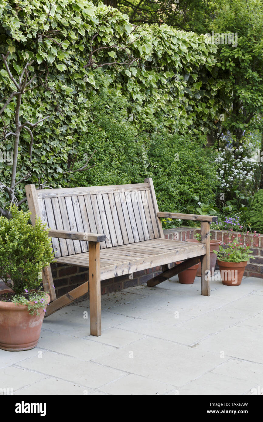 Banc de jardin en bois traditionnel sur un patio dans un jardin anglais  Photo Stock - Alamy