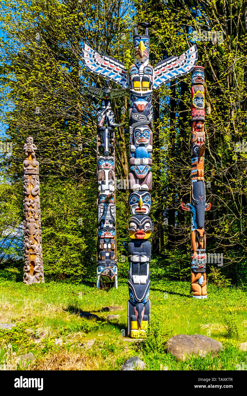 Les Totems colorés représentant des symboles religieux et d'art de la côte ouest les peuples autochtones situé dans le parc Stanley à Vancouver, Canada Banque D'Images