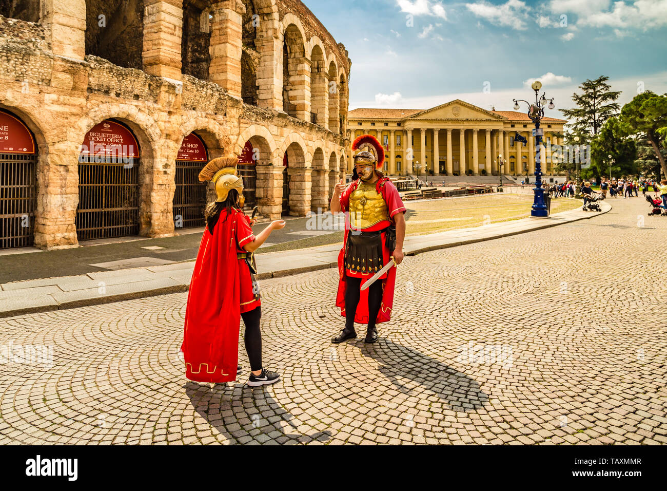 VERONA (VR), ITALIE - 10 MAI 2019 : les touristes visitant l'Arène de Vérone et acteurs en costumes romains conversent Banque D'Images