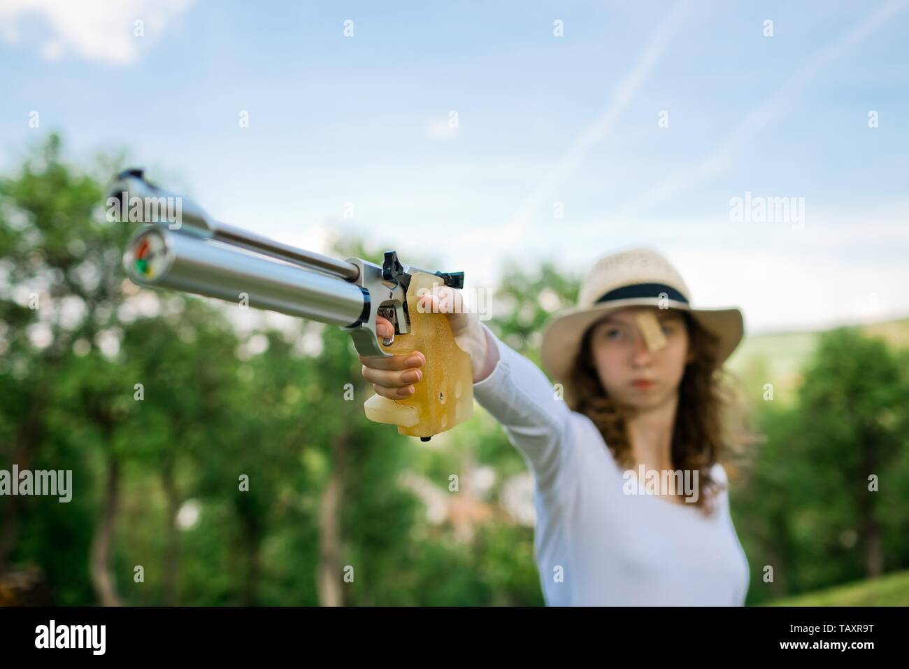 Visant le sport de tir féminin, détail sur hand holding emprise de 10 mètres, au pistolet à air comprimé tirant de déclenchement en action Banque D'Images