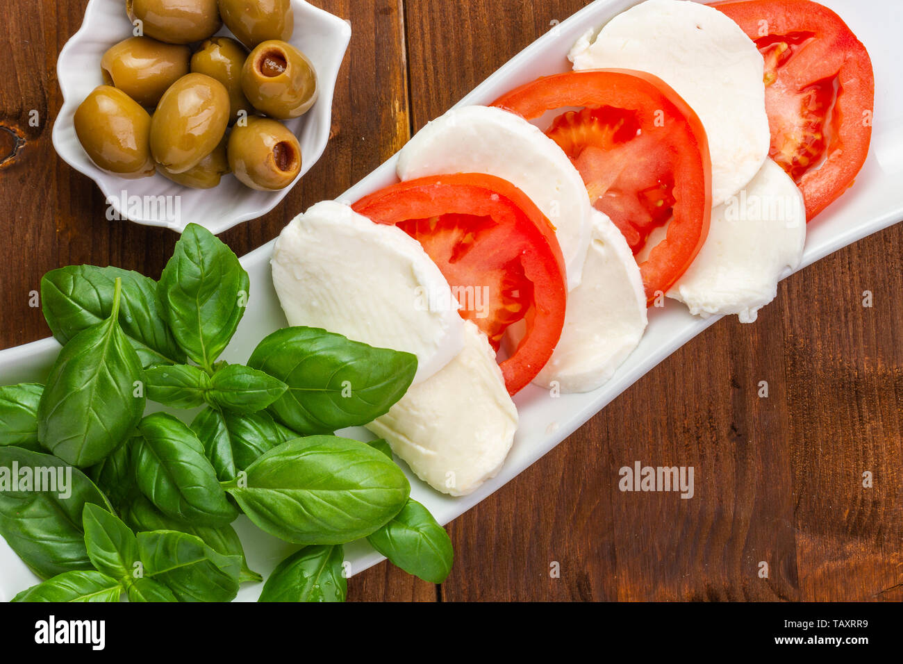 La mozzarella fraîche et les tomates et basilic. Repas végétarien. La cuisine italienne. Les couleurs italiennes. Banque D'Images