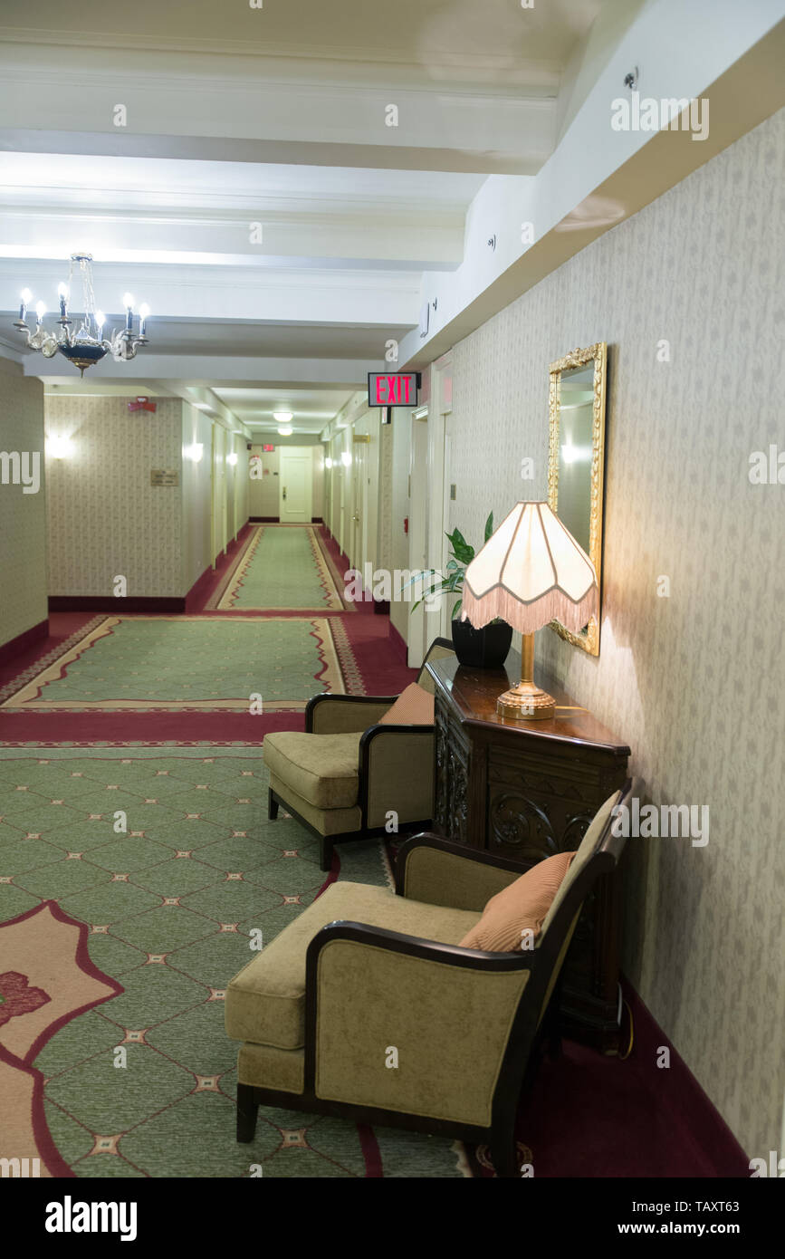 Hotelflur Sesseln und mit einem QUITTER-Schild, NYC, USA / couloir de l'hôtel avec des fauteuils et un panneau de sortie, NYC, USA. Banque D'Images