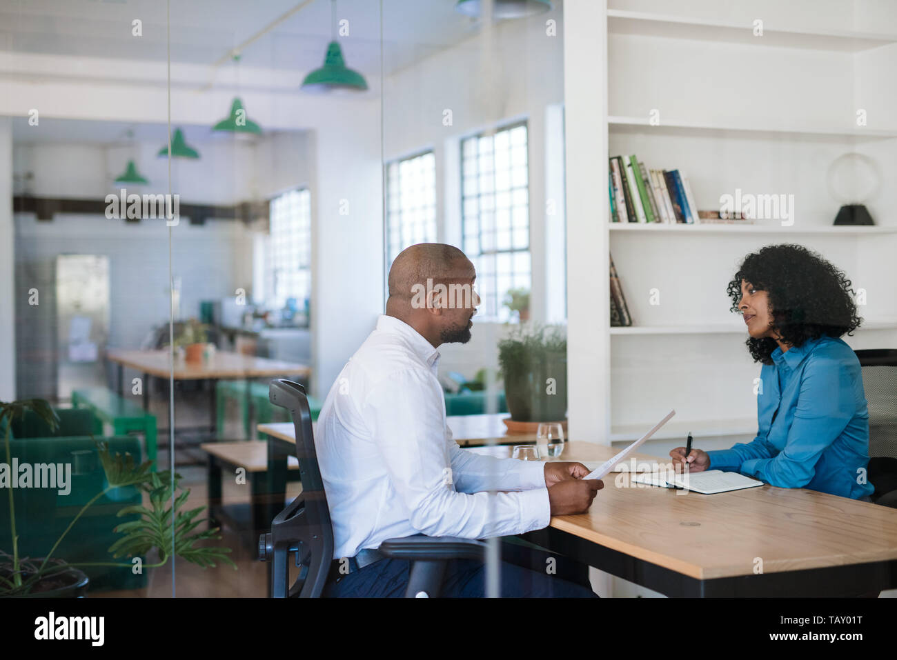 Manager la conduite d'un entretien avec un potentiel nouvel employé à son bureau à l'intérieur d'un bureau Banque D'Images