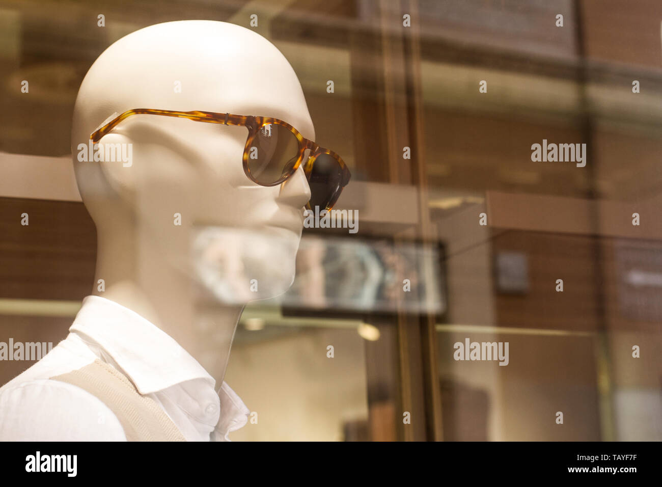 Vue de côté libre de plastique blanc homme mannequin portant des lunettes de soleil en magasin de vêtements présentation fenêtre Banque D'Images