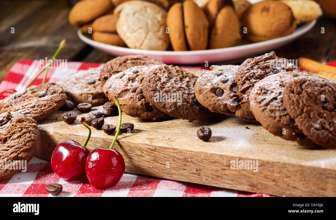 Les cookies au chocolat à l'avoine avec des grains de café et de cerise. Serveur Sun flare Banque D'Images