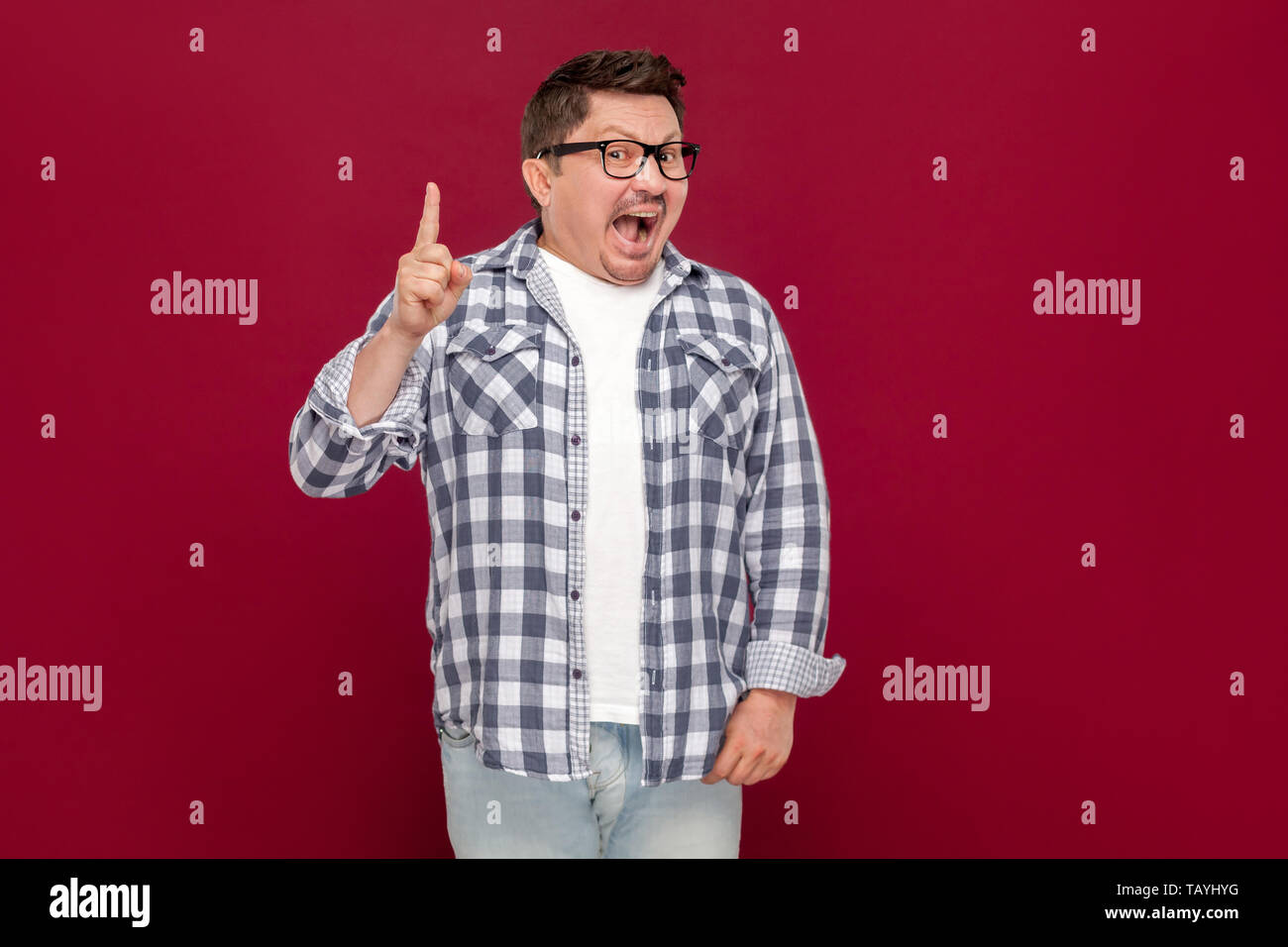 Idée. Portrait d'un génie handsome middle aged man in casual chemise à carreaux et des lunettes à permanent et heureux avec sa nouvelle idée. Banque D'Images