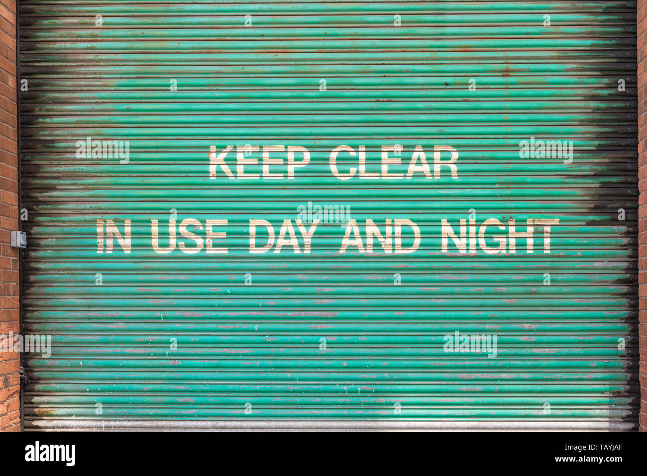 Volet roulant vieux vert avec écrit peint sur : Rester à l'écart de l'utilisation jour et nuit Banque D'Images