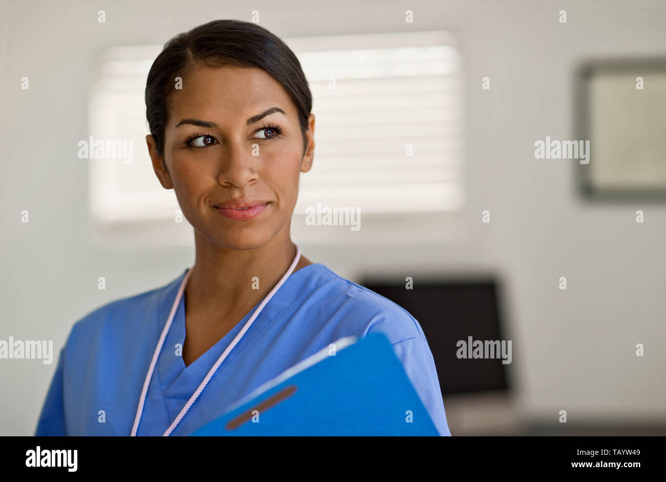 Jolie jeune infirmière à la réflexion qu'elle examine un patient remarque. Banque D'Images