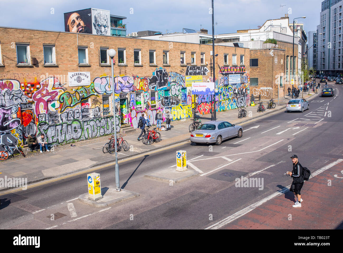 Shoreditch, London, England, UK - Avril 2019 : Hipster homme traversant la route sur route près de Bethnal Green Shoreditch high street station et BOXPARK Banque D'Images