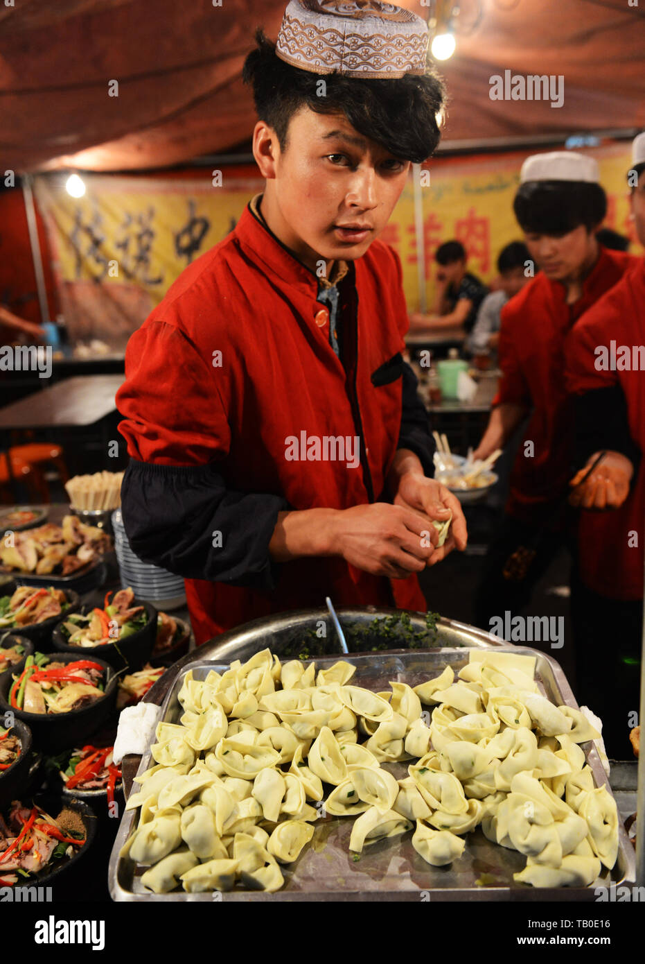 Préparation de petites boulettes en un restaurant dans le marché de nuit de Linxia. Banque D'Images