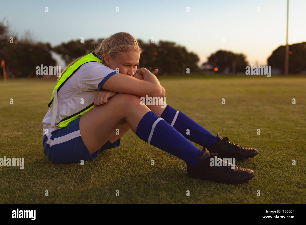 Joueur de football relaxing on grass Banque D'Images