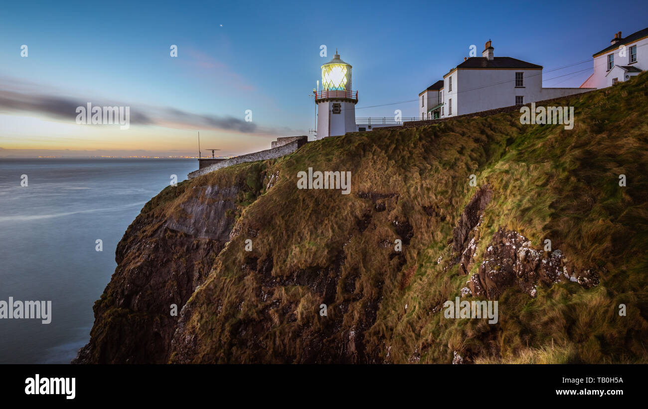 L'aube à tête noire phare, le comté d'Antrim, en Irlande du Nord. Banque D'Images