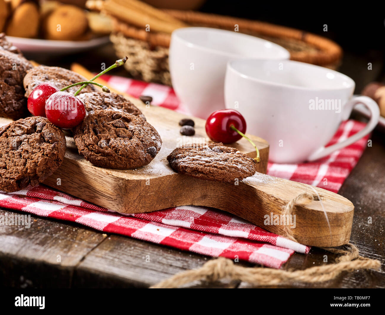 Les cookies au chocolat à l'avoine avec des grains de café et de cerise. Serveur Sun flare Banque D'Images