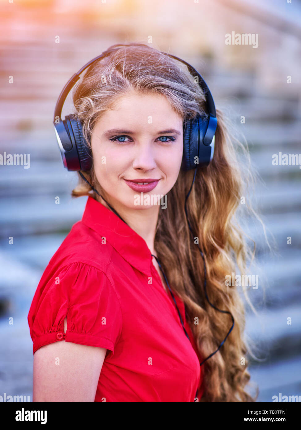 Fille de casques d'écoute de la musique descendant des escaliers Banque D'Images