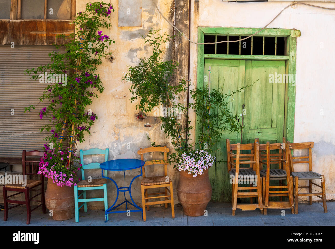 Chaises empilées à l'extérieur de Greek street cafe, Agio Nikolaos, Crète Banque D'Images