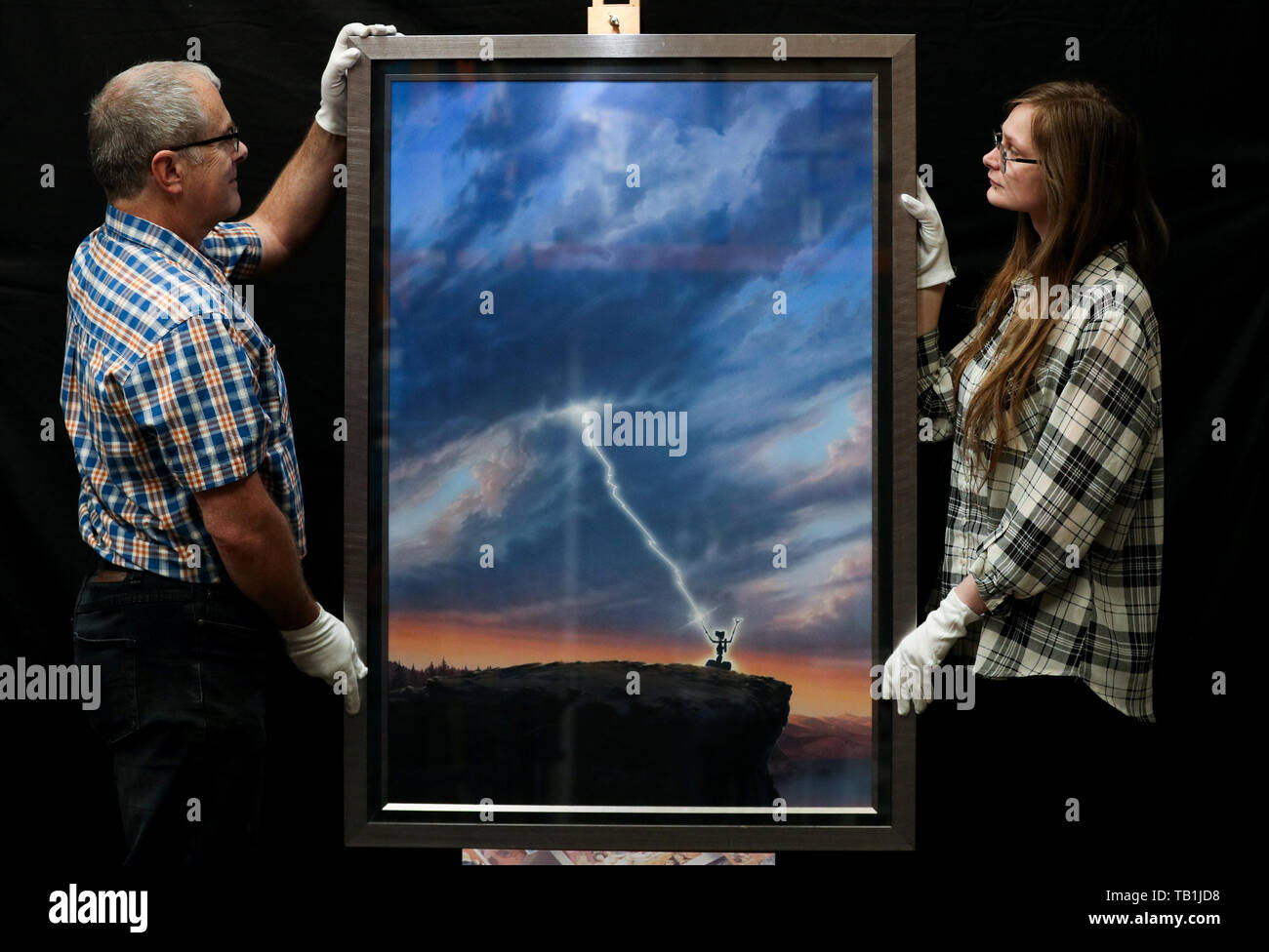 Les employés du magasin Prop adapter une œuvre d'art originale d'une affiche pour la conception du film 1986 « court-circuit' par l'artiste John Alvin, lors d'un aperçu de la prochaine vente aux enchères d'affiches de cinéma à la prop Store siège social près de Rickmansworth. Banque D'Images