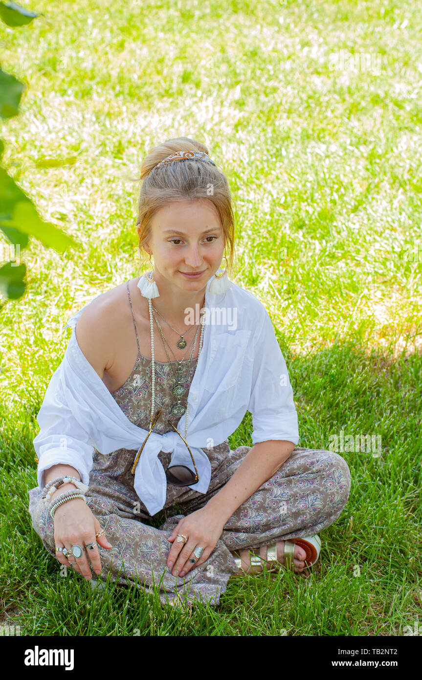 Belle femme style Boho avec accessoires, bagues et bracelets profitant de  l'été journée ensoleillée en parc. Hippie bohème fille est assis sur  l'herbe Photo Stock - Alamy