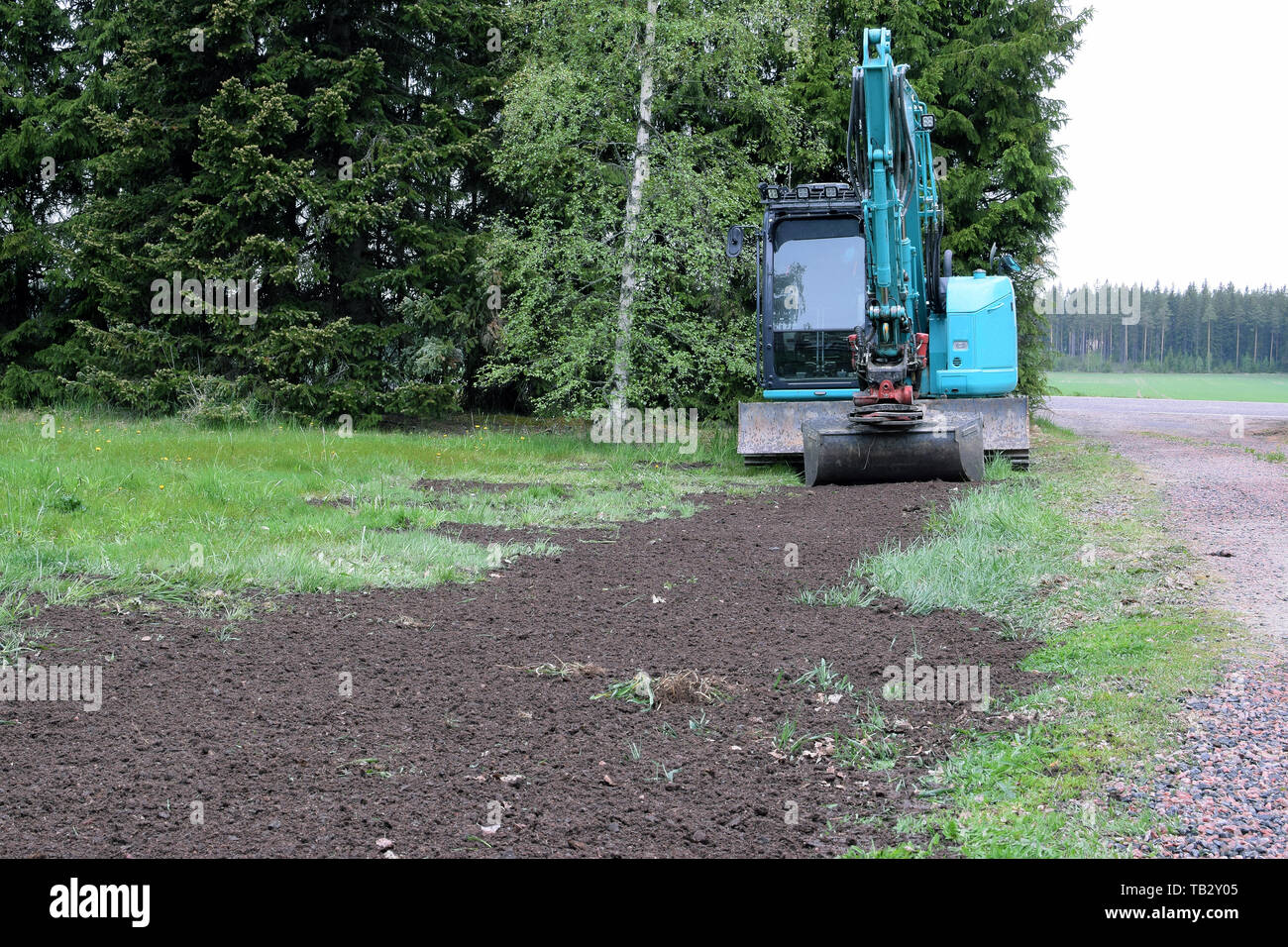 Petit jardin à l'excavatrice de faire l'aménagement paysager. Banque D'Images