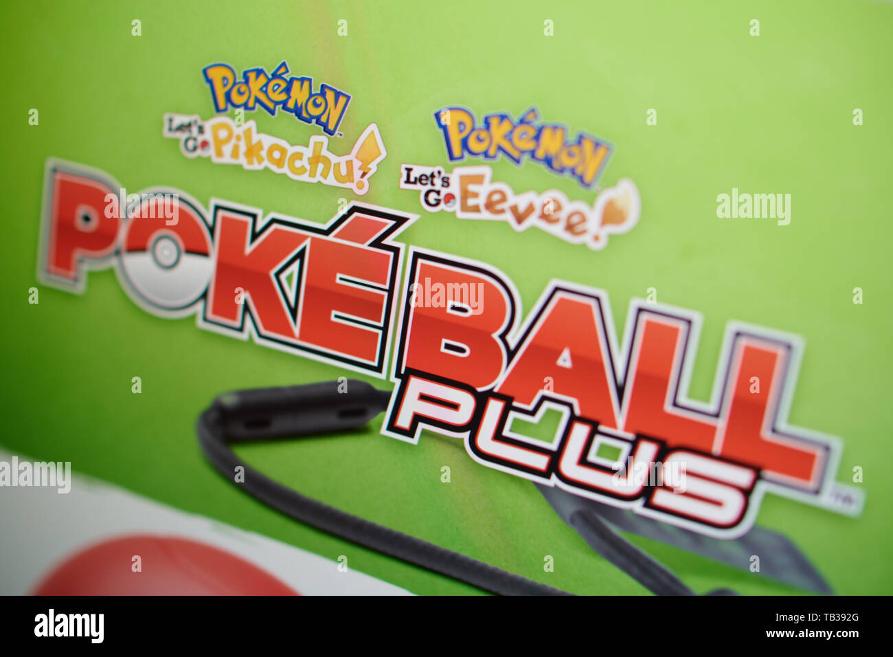 Gros plan sur Pokéball Plus accessoire de jeu Nintendo pour passer de l'écran du site photographié. Banque D'Images