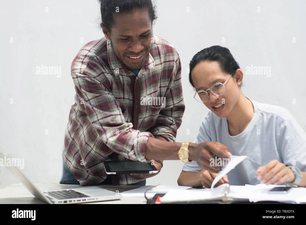 Deux ami avec différents groupes ethniques travaillent ensemble avec ordinateur portable et tablette aborder quelque chose, deux jeune homme travailler et étudier ensemble Banque D'Images