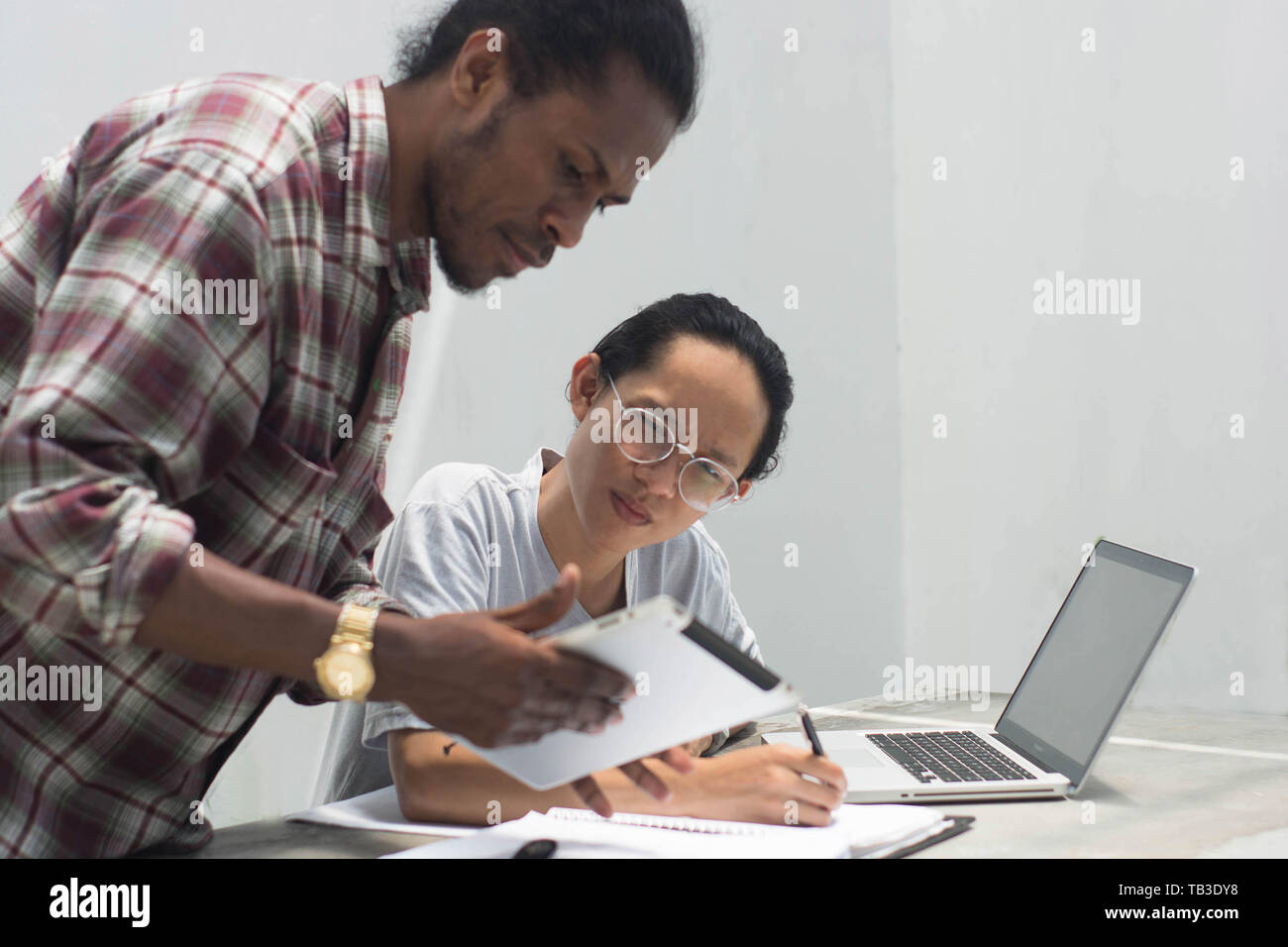 Deux ami avec différents groupes ethniques travaillent ensemble avec ordinateur portable et tablette aborder quelque chose, deux jeune homme travailler et étudier ensemble Banque D'Images