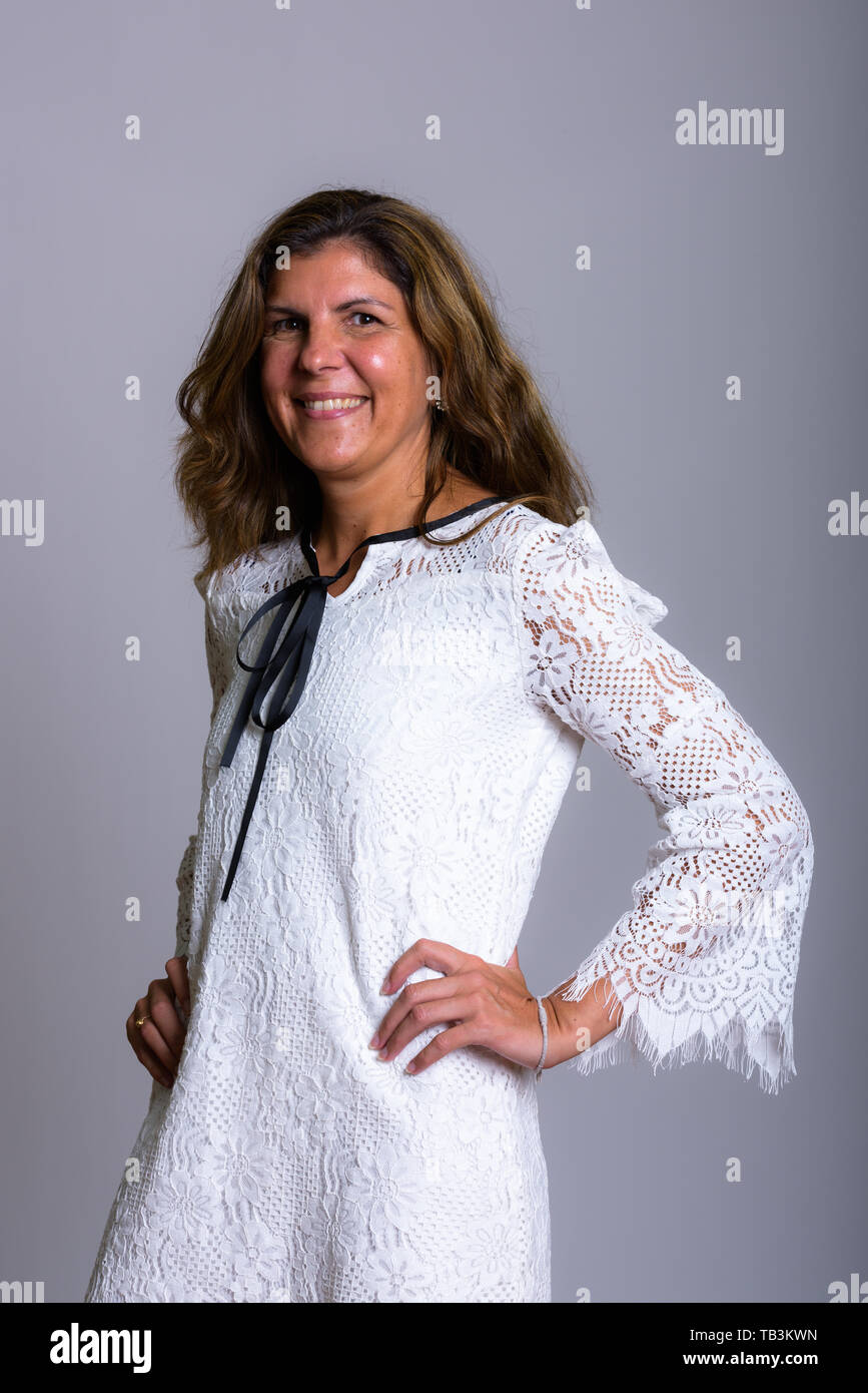 Studio shot of young woman smiling and posing with hands Banque D'Images
