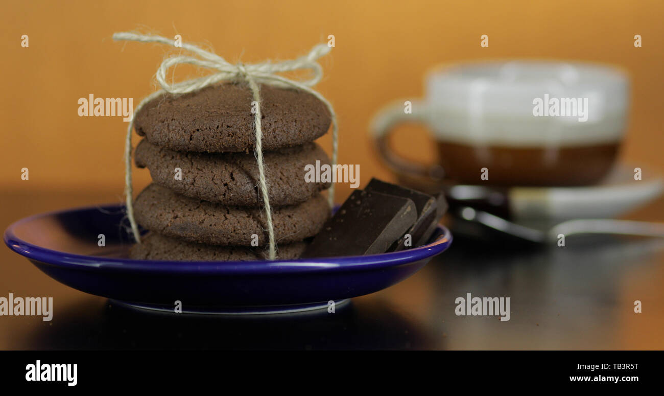 Délicieux chocolat à biscuit sur une plaque bleue sur la surface sombre. Vintage fond chaud Banque D'Images