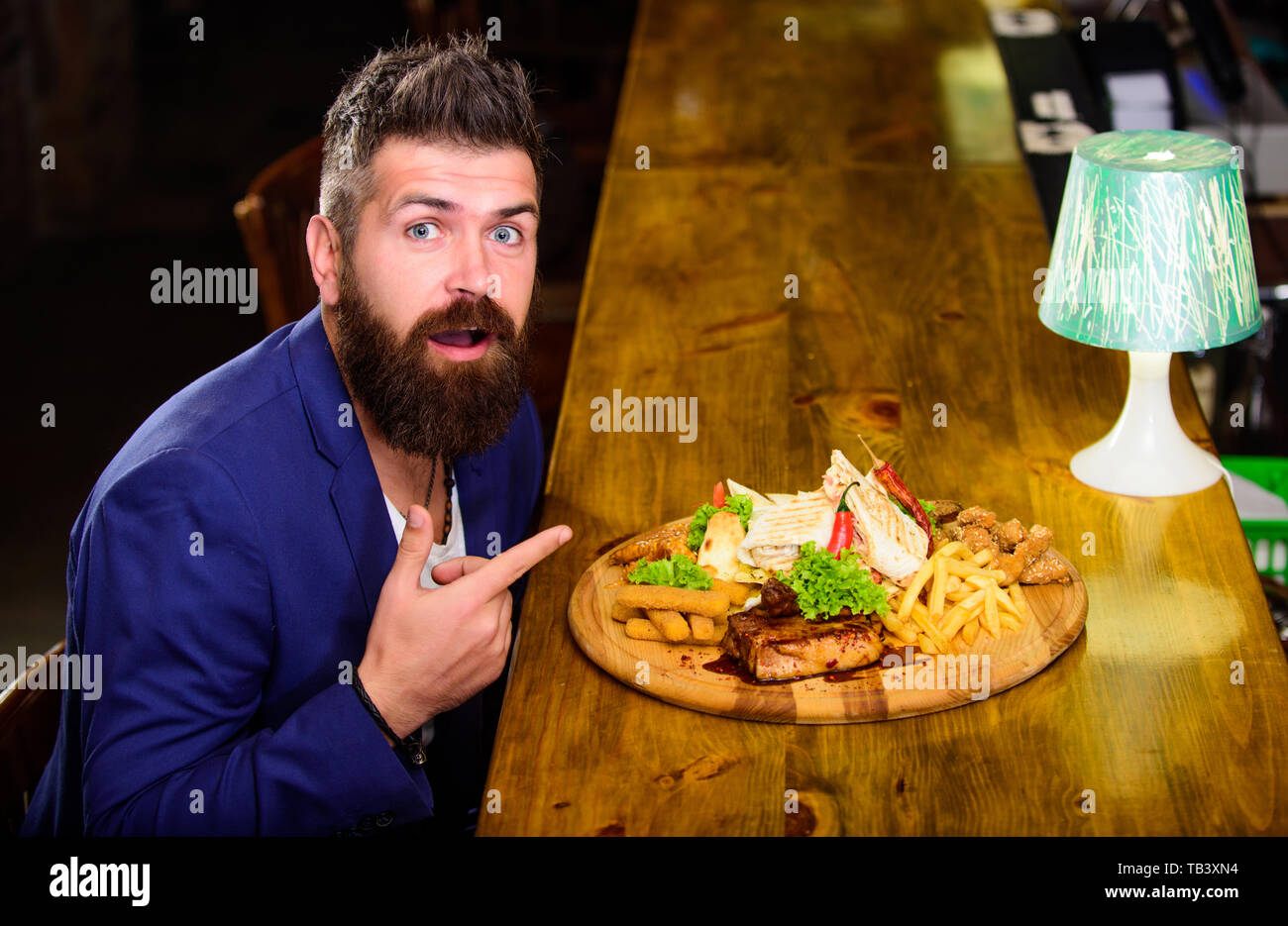 Vous pourrez vous détendre après une dure journée de travail. Woman costume formel s'asseoir à comptoir bar. L'homme a reçu de pommes de terre frites repas avec viande et poisson, lavash. Profitez de repas. Il méritent de délicieux repas. Des calories. Banque D'Images