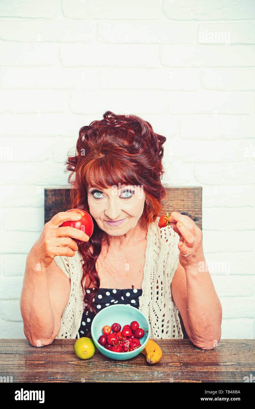 Senior woman smile avec Apple et de fraise, de vitamine Banque D'Images