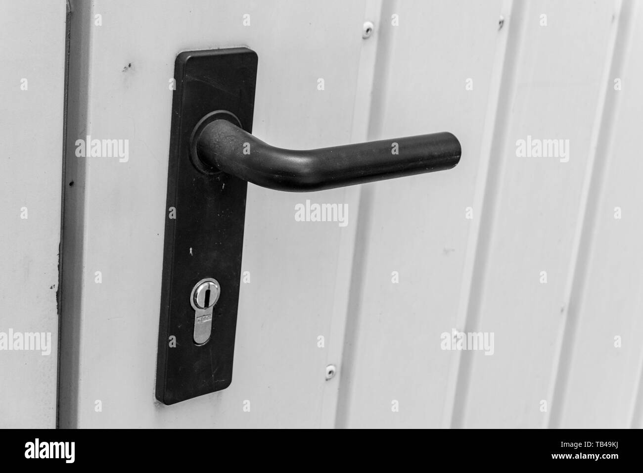 Poignée de porte noire avec verrou à un porte pour le garage fait de tôle  Photo Stock - Alamy