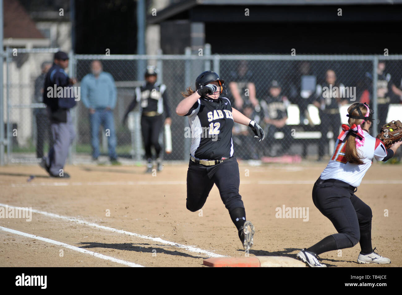 Un batteur/coureur sautant pour première base dans un effort pour sortir de la jambe un infield rez-ball, toutefois, le jeter à la battre le sac comme elle était à la retraite. USA. Banque D'Images