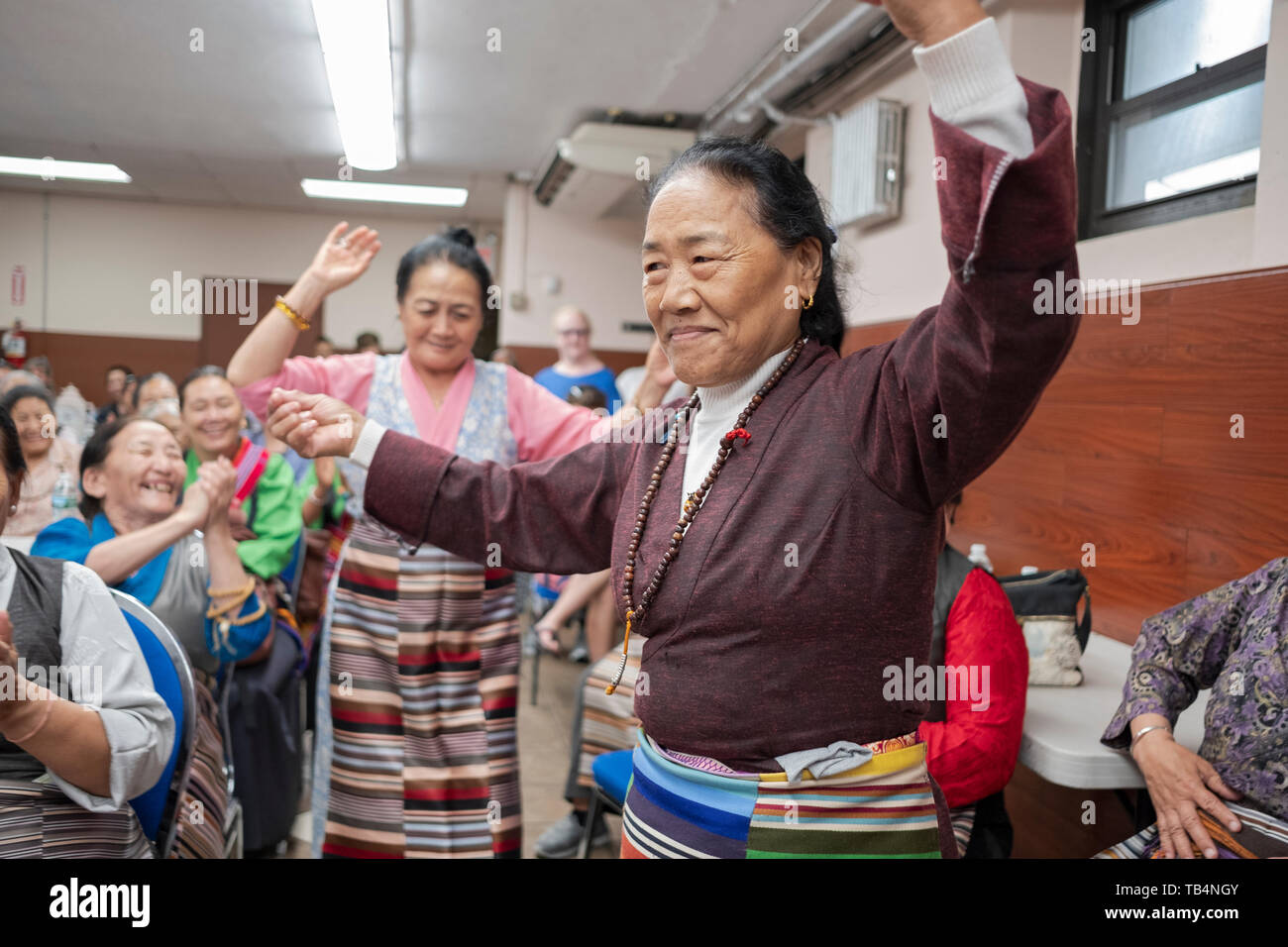 Les femmes d'Asie, du Népal et du Tibet, la danse dans les allées à un concert de musique de l'Himalaya au temple bouddhiste Sherpa dans le Queens, New York. Banque D'Images
