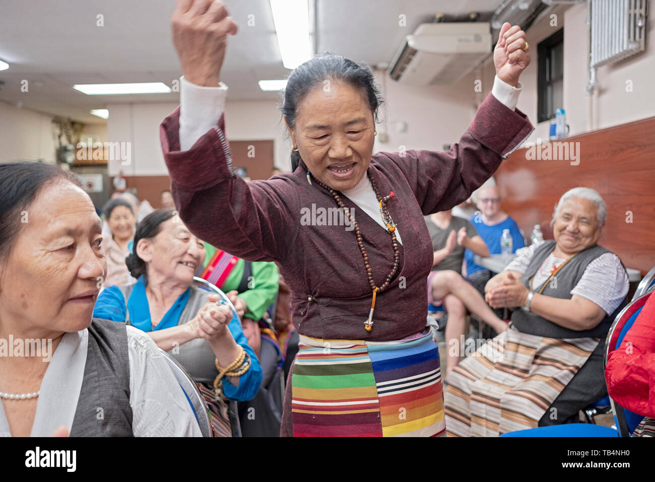 Une Népalaise danses des femmes dans les allées à un concert de musique de l'Himalaya au temple bouddhiste Sherpa dans le Queens, New York. Banque D'Images