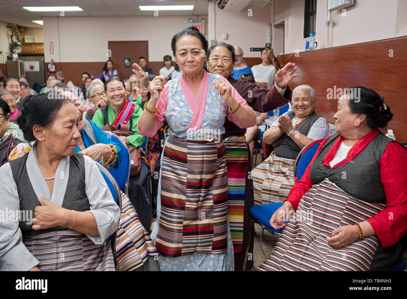 Les femmes d'Asie, du Népal et du Tibet, la danse dans les allées à un concert de musique de l'Himalaya au temple bouddhiste Sherpa dans le Queens, New York. Banque D'Images