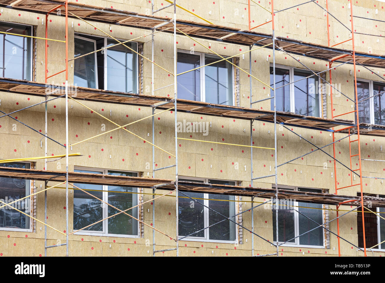 Isolation thermique de mur de la maison avec de la laine minérale. échafaudages près de façade d'un bâtiment pour la restauration Banque D'Images