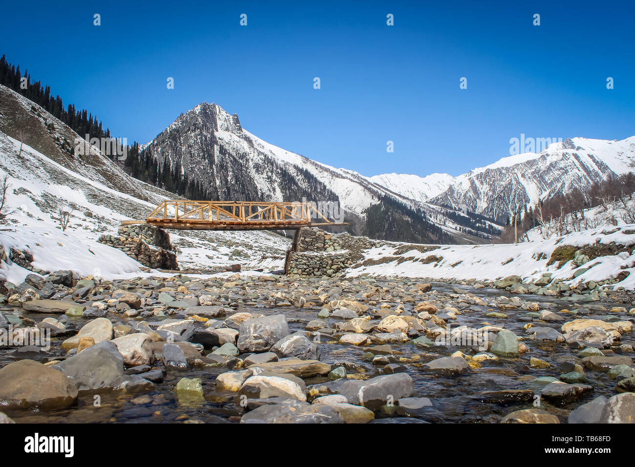 Un nouveau pont de bois construit sur un petit cours d'eau dans la région montagneuse de l'Himalaya au Cachemire Sonmarg piédestal de mouvement. De hautes montagnes Banque D'Images