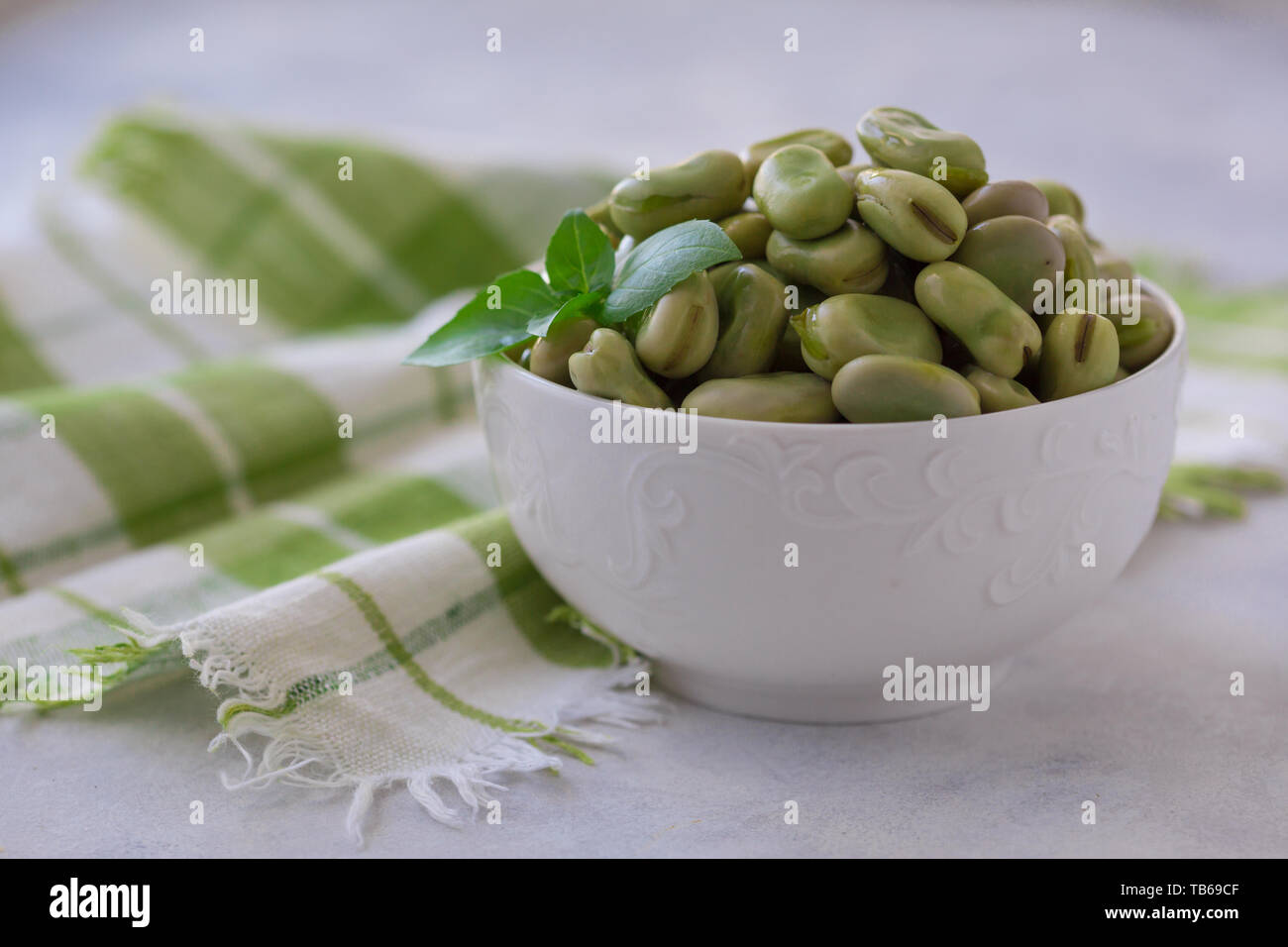 Haricots verts cuits sur la plaque. Close up de haricots verts cuits sur la plaque et le plat végétalien sain avec feuille de basilic Banque D'Images